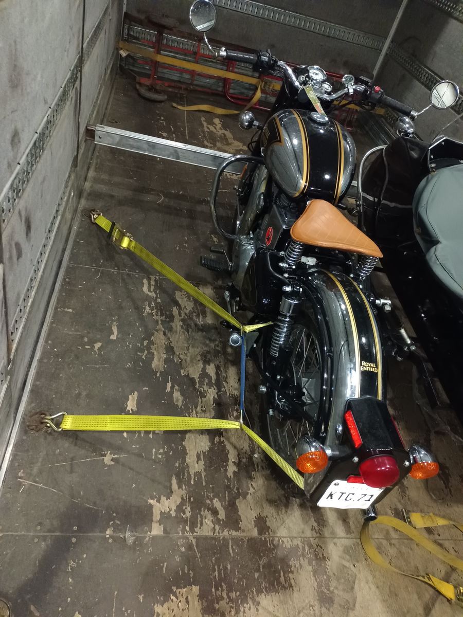 Moto con sidecar amarrada con correas dentro del camión